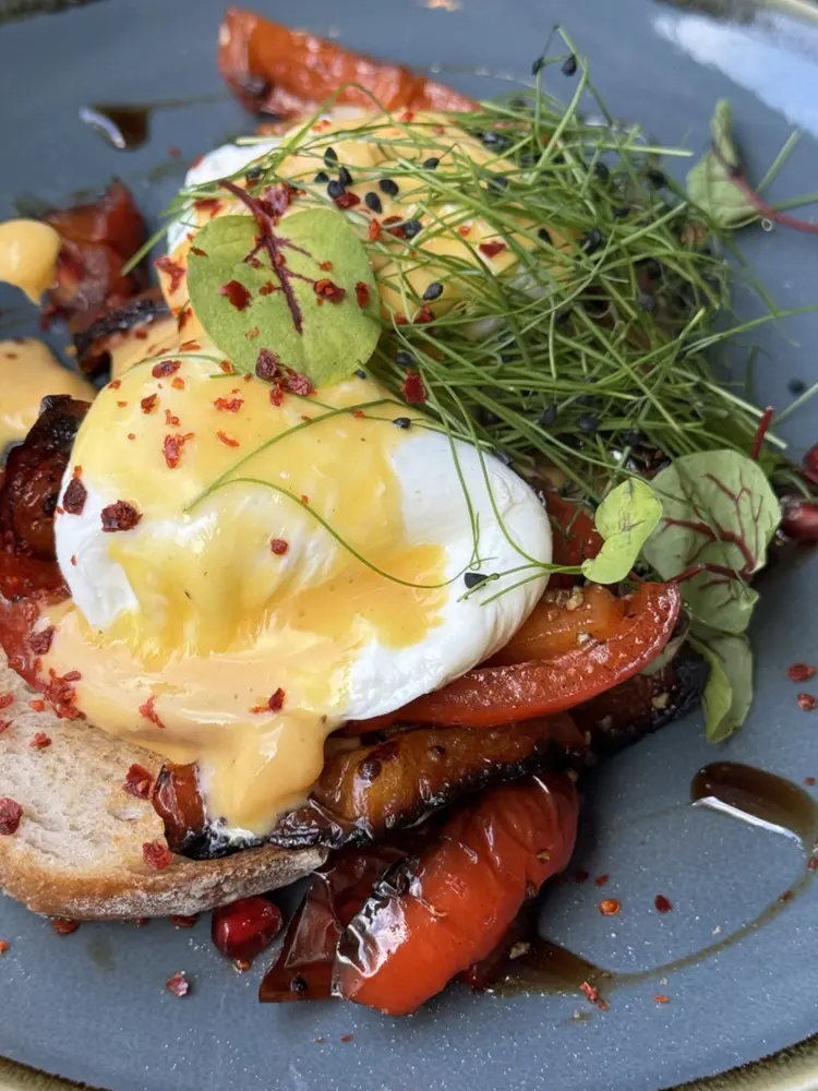 Poached eggs with hollandaise and roast peppers on toast