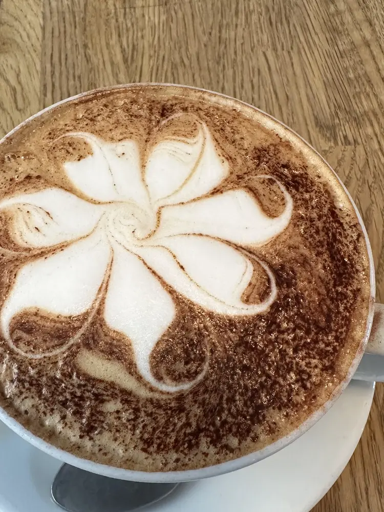 Cappuccino with flower latte art dusted with chocolate